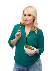 Image showing smiling young woman eating vegetable salad