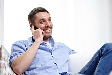 Image showing happy man calling on smartphone at home