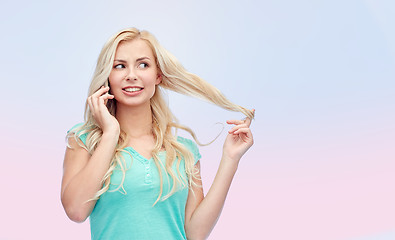 Image showing smiling young woman calling on smartphone