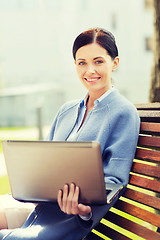 Image showing smiling business woman with laptop in city