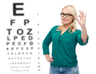 Image showing smiling young woman with eyeglasses showing ok