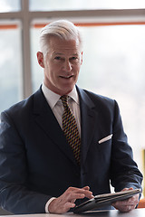 Image showing senior business man working on tablet computer