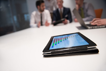 Image showing close up of touchpad with analytics documents at business meetin