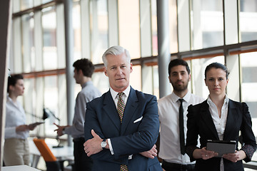 Image showing portrait of senior businessman as leader  with group of people i