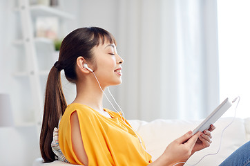 Image showing happy asian woman with tablet pc and earphones