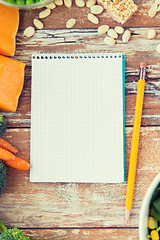 Image showing close up of ripe vegetables and notebook on table