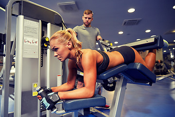 Image showing man and woman flexing muscles on gym machine