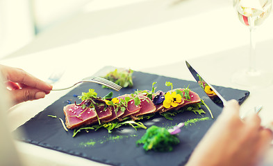 Image showing close up of woman eating salad at restaurant