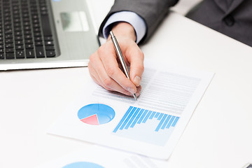 Image showing close up of businessman hand with charts in office