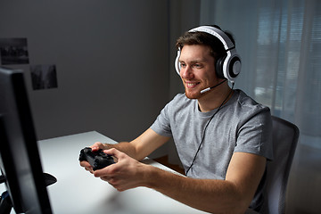 Image showing man in headset playing computer video game at home