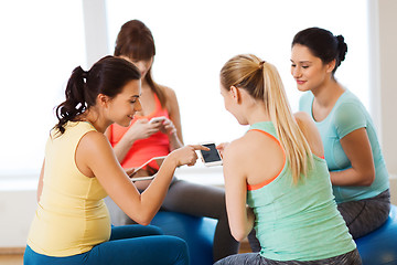 Image showing happy pregnant women with gadgets in gym