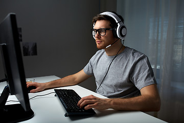 Image showing man in headset playing computer video game at home