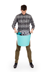 Image showing Full length portrait of a young man holding a laundry basket