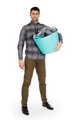 Image showing Full length portrait of a young man holding a laundry basket