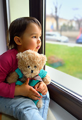 Image showing Little girl looking out the window