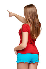 Image showing Back view of a young female pointing at copy space