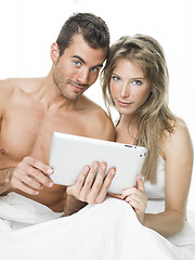 Image showing attractive couple watching things in a tablet