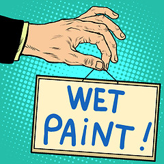 Image showing Hand holding a sign wet paint 