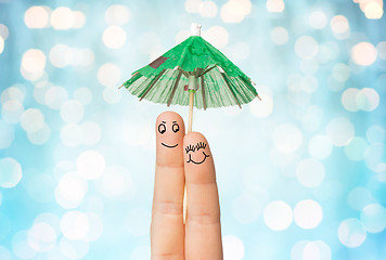 Image showing close up of two fingers with cocktail umbrella
