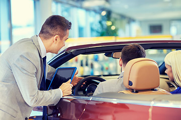 Image showing happy couple with car dealer in auto show or salon