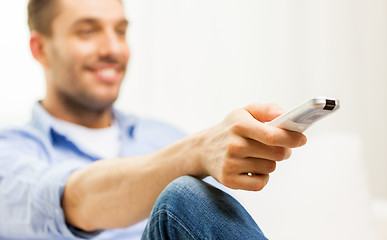 Image showing close up of man with tv remote control at home