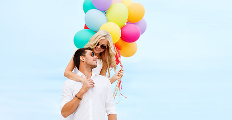 Image showing couple with colorful balloons at seaside