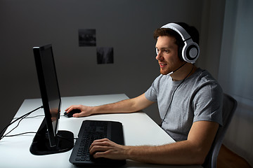 Image showing man in headset playing computer video game at home