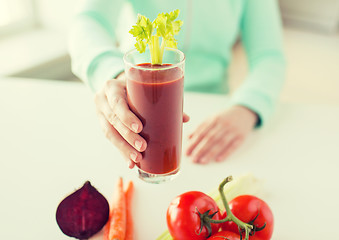 Image showing close up of woman hands with juice and vegetables