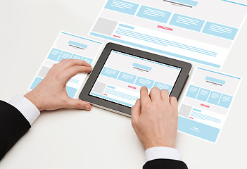 Image showing close up of hands with web design on tablet pc