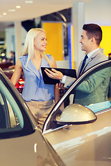 Image showing happy woman with car dealer in auto show or salon