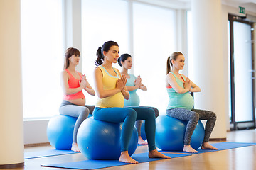 Image showing happy pregnant women exercising on fitball in gym