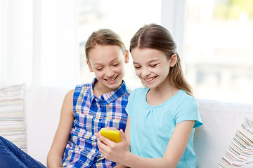 Image showing happy girls with smartphone sitting on sofa