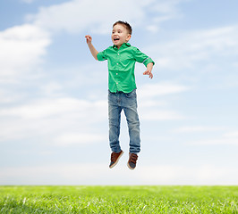 Image showing happy little boy jumping in air