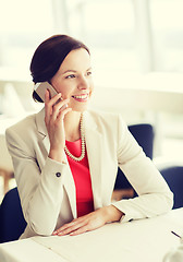 Image showing happy woman calling on smart phone at restaurant