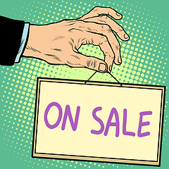 Image showing Hand holding a sign on sale