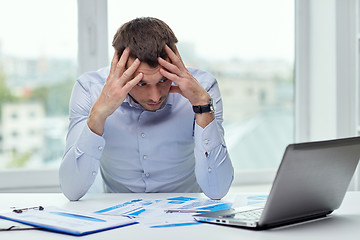 Image showing stressed businessman with laptop at office