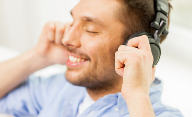 Image showing smiling young man in headphones at home