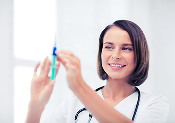 Image showing female doctor holding syringe with injection