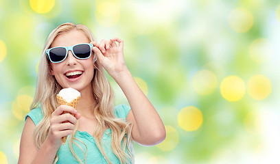 Image showing happy young woman in sunglasses eating ice cream