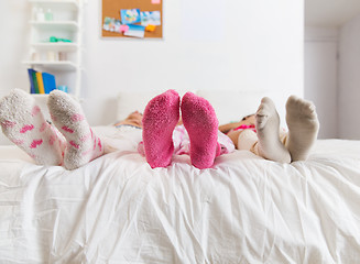 Image showing close up of women feet in socks on bed at home