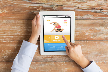 Image showing close up of hands with sport app on tablet pc