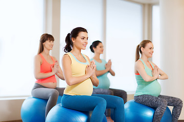 Image showing happy pregnant women exercising on fitball in gym