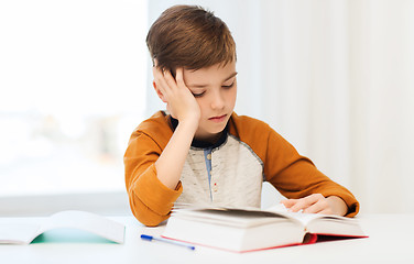 Image showing student boy reading book or textbook at home