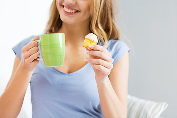 Image showing close up of happy woman or teen girl with cupcake