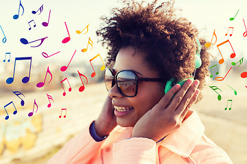 Image showing happy young woman in headphones listening to music