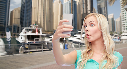 Image showing funny young woman taking selfie with smartphone