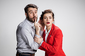 Image showing Young man telling gossips to his woman colleague at the office