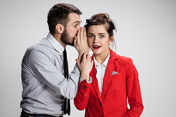 Image showing Young man telling gossips to his woman colleague at the office