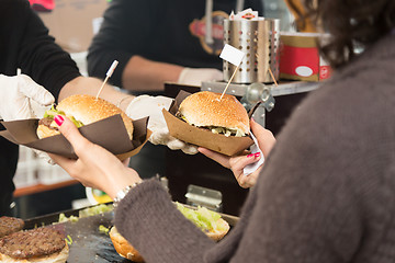 Image showing Beef burgers being served on street food stall