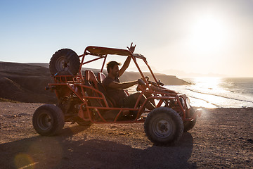 Image showing Man driving quadbike in sunset.